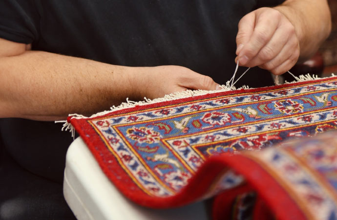 a person is repairing a rug