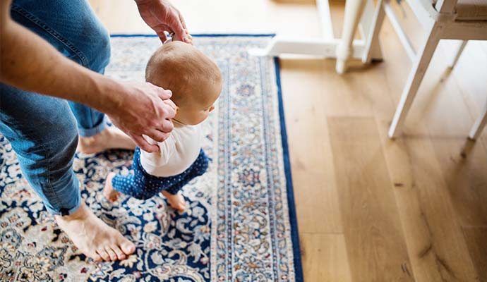 father with a baby girl at home steps in rugs