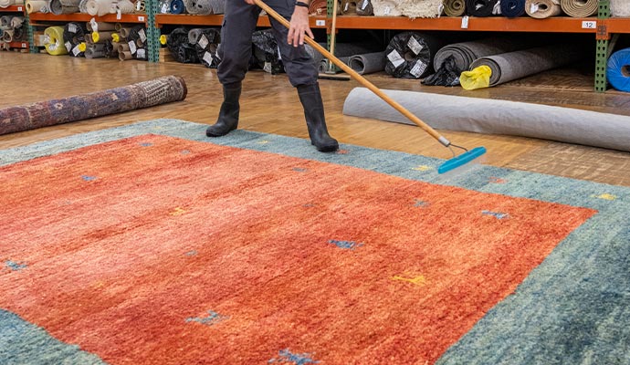 man rug cleaning broom storage