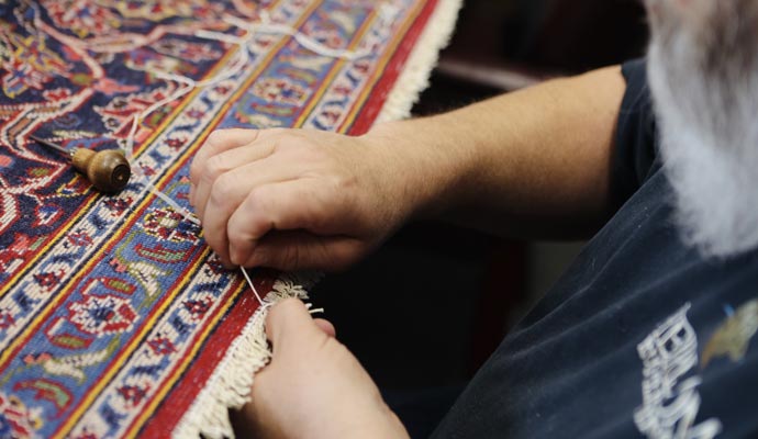 A person repairing a rug using equipment