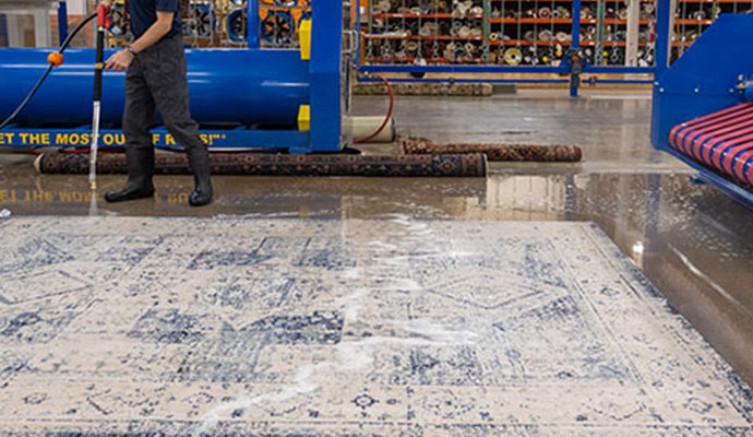 worker washing rug professionally